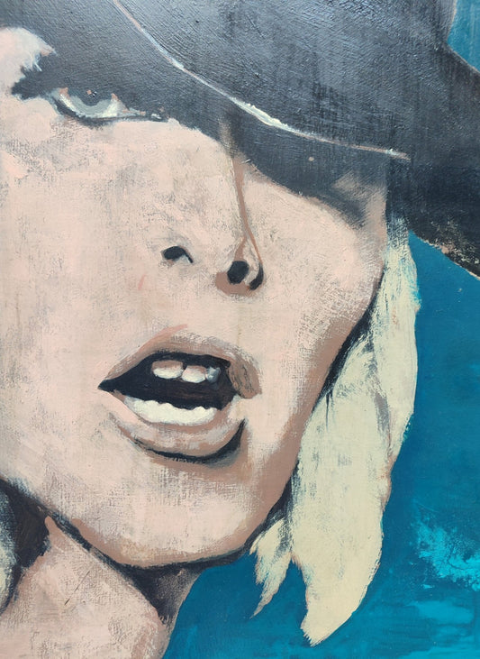 Pablo Mañé Kati Girl, retrato femenino contemporáneo con sombrero negro sobre fondo azul intenso detalle rostro y labios